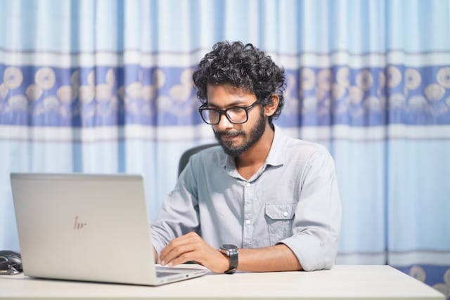 Remote software developer working at a desk with multiple monitors and a globe overlay representing distributed teams
